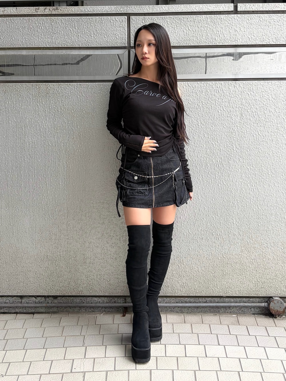 ブラック系のTシャツ/カットソー、ブラック系のスカート、ブラック系のブーツを着用したレディースの秋コーディネートの2枚目の写真