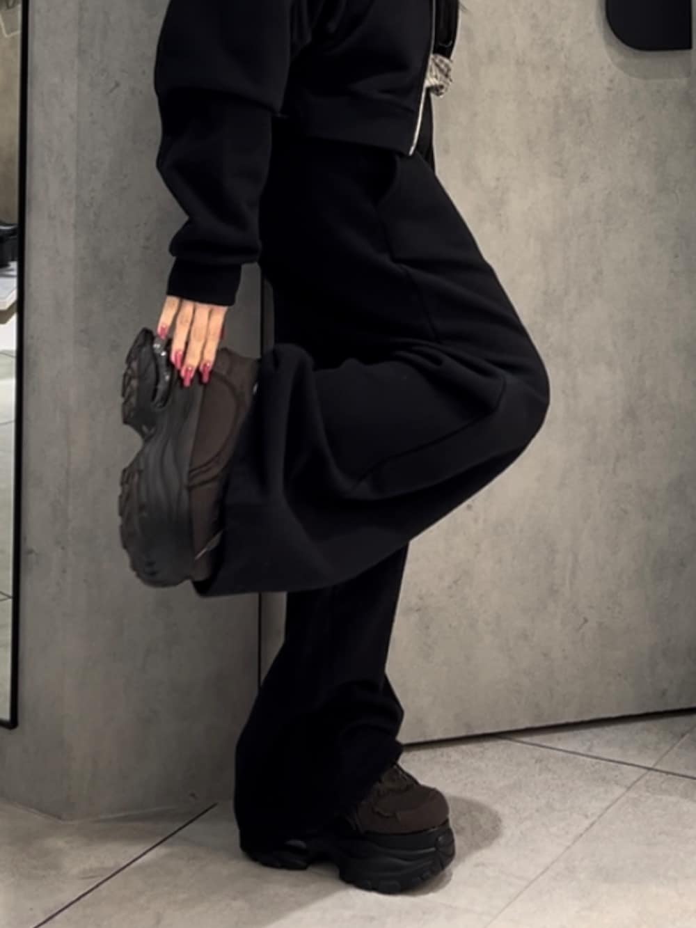 ホワイト系のニット/セーター、ブラック系のパーカー、ブラック系のスウェットパンツを着用したレディースの冬コーディネートの9枚目の写真