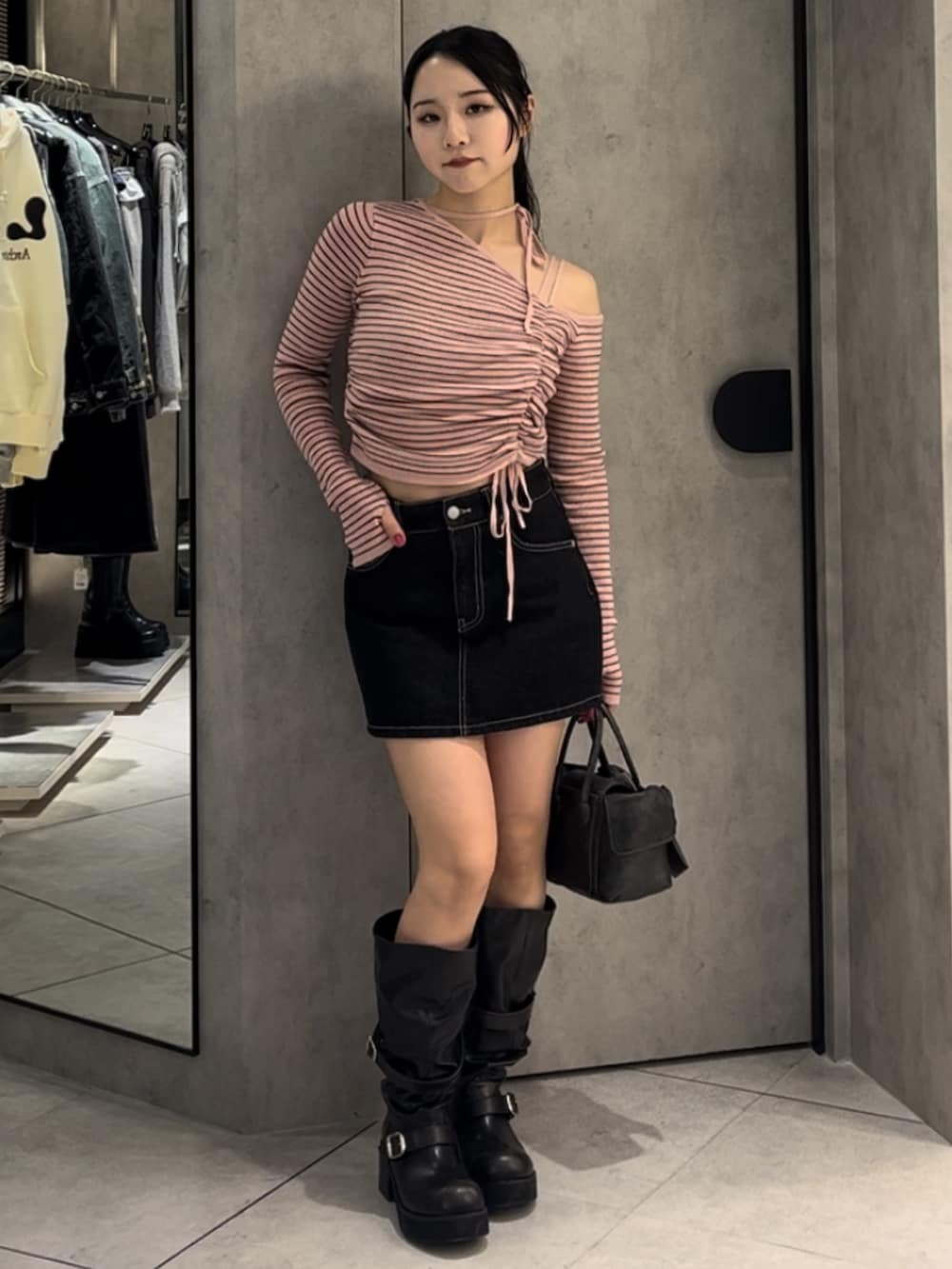 ピンク系のニット/セーター、ブルー系のスカート、ブラウン系のハンドバッグを着用したレディースの冬コーディネートの8枚目の写真