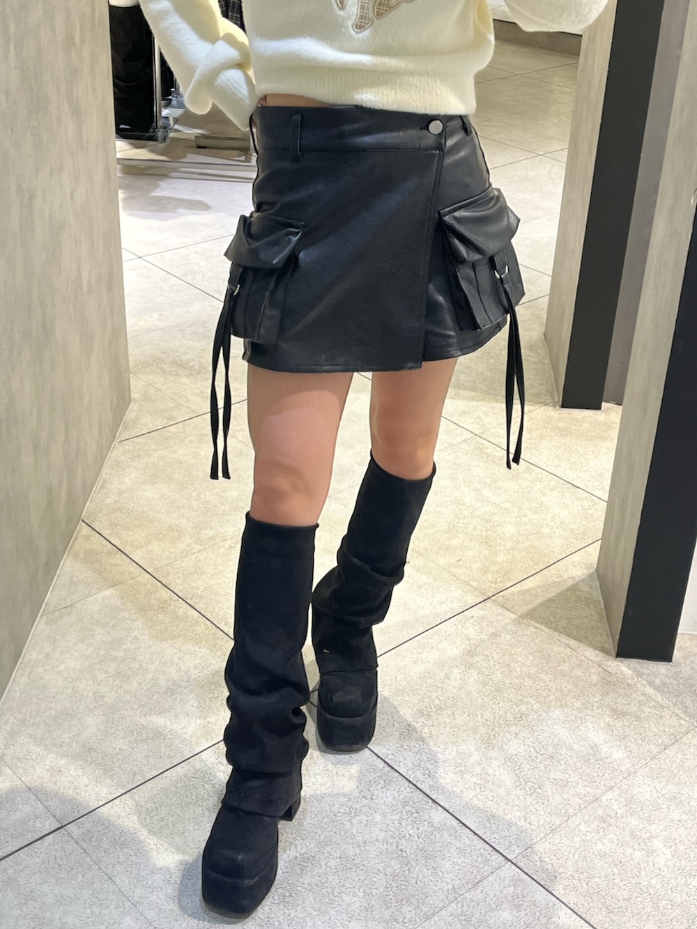 ホワイト系のニット/セーター、ブラック系のその他パンツ、ブラック系のブーツを着用したレディースの冬コーディネートの7枚目の写真