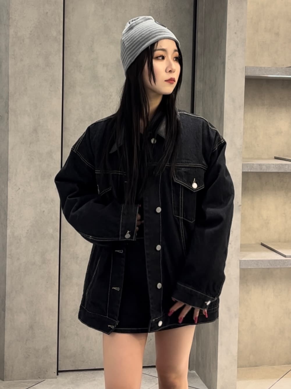 ブルー系のブルゾン、ブラック系のニット/セーター、ブルー系のスカートを着用したレディースの冬コーディネートの5枚目の写真