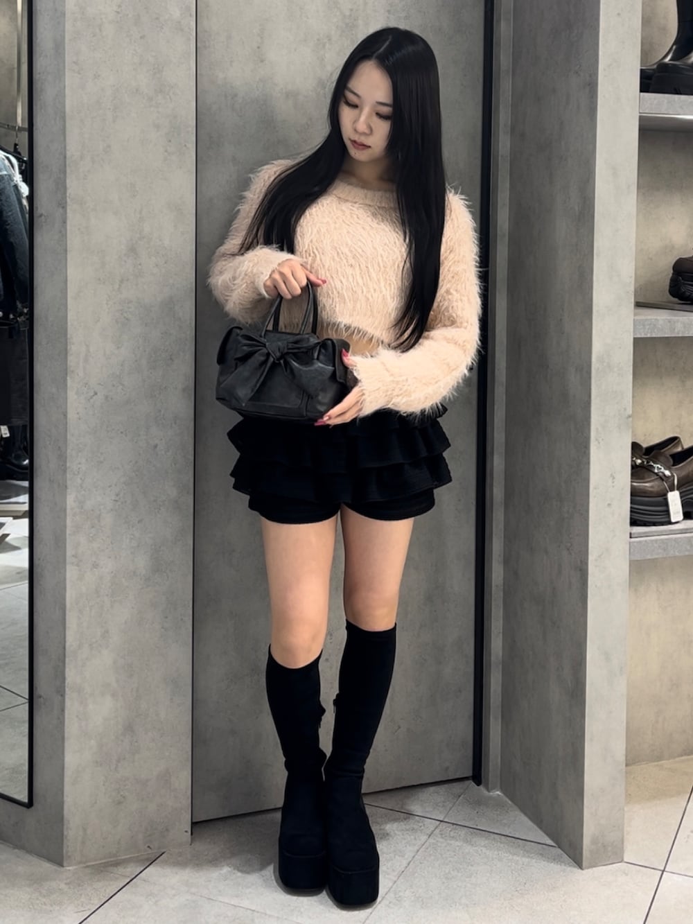 ピンク系のニット/セーター、ブラック系のハンドバッグ、ブラック系のその他パンツを着用したレディースの冬コーディネートの7枚目の写真