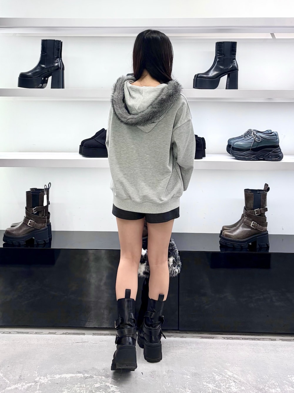 グレー系のパーカー、ブラック系のショルダーバッグ、ブラック系のその他パンツを着用したレディースの秋コーディネートの4枚目の写真