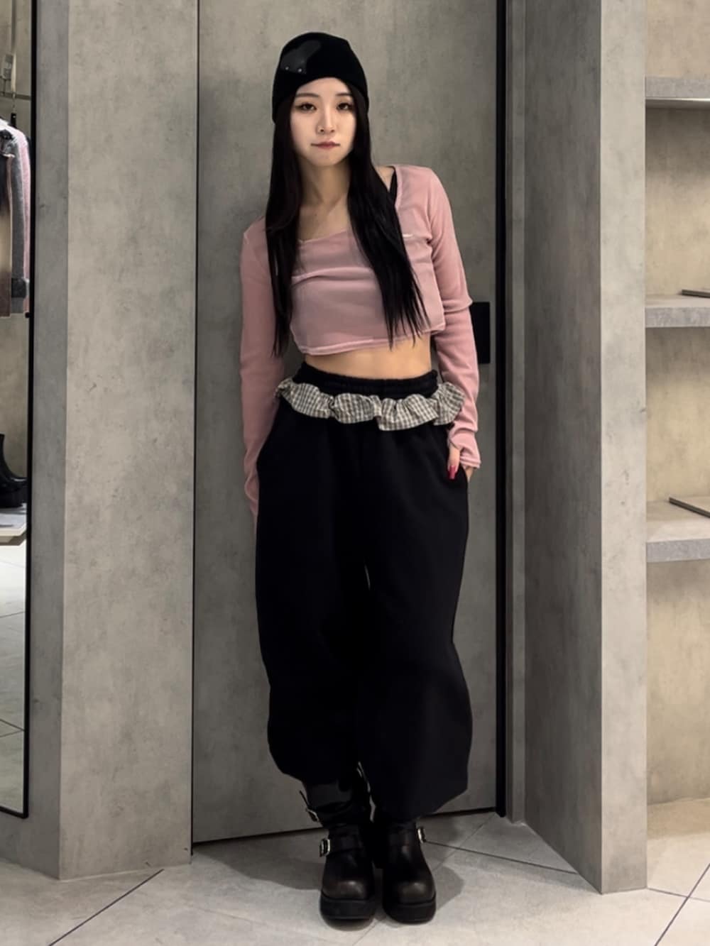 ピンク系のTシャツ/カットソー、ブラック系のスウェットパンツ、ブラック系のブーツを着用したレディースの冬コーディネートの2枚目の写真