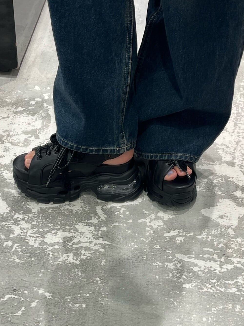 ブルー系のデニムパンツ、グレー系のニット/セーター、ブラック系のサンダルを着用したレディースの春コーディネートの8枚目の写真