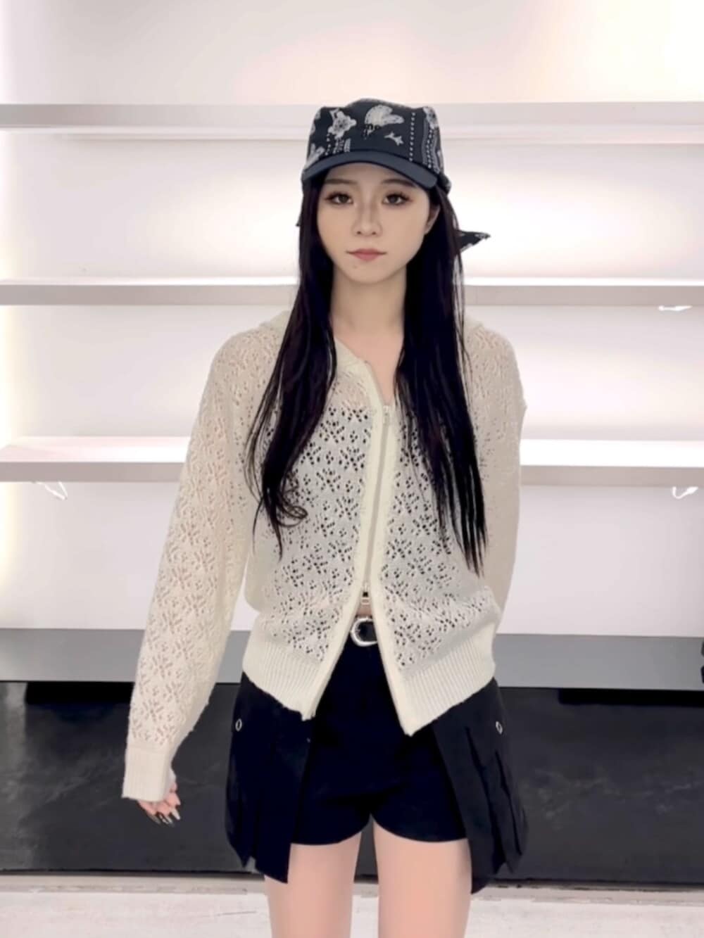 ブラック系のサンダル、ホワイト系のパーカー、ブラック系のスカートを着用したレディースの春コーディネートの5枚目の写真