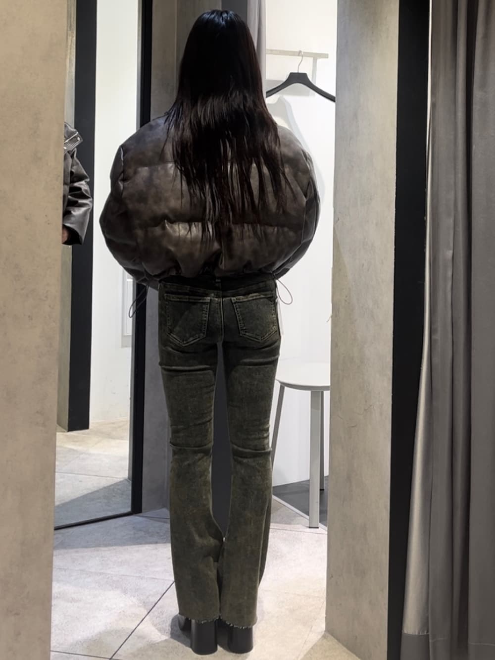 ブラウン系のダウンジャケット/コート、ホワイト系のニット/セーター、ブルー系のデニムパンツを着用したレディースの冬コーディネートの3枚目の写真