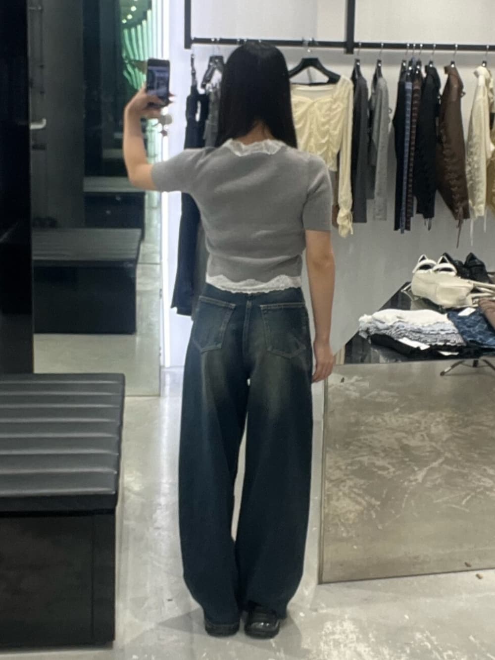 ブルー系のデニムパンツ、グレー系のニット/セーター、ブラック系のサンダルを着用したレディースの春コーディネートの3枚目の写真