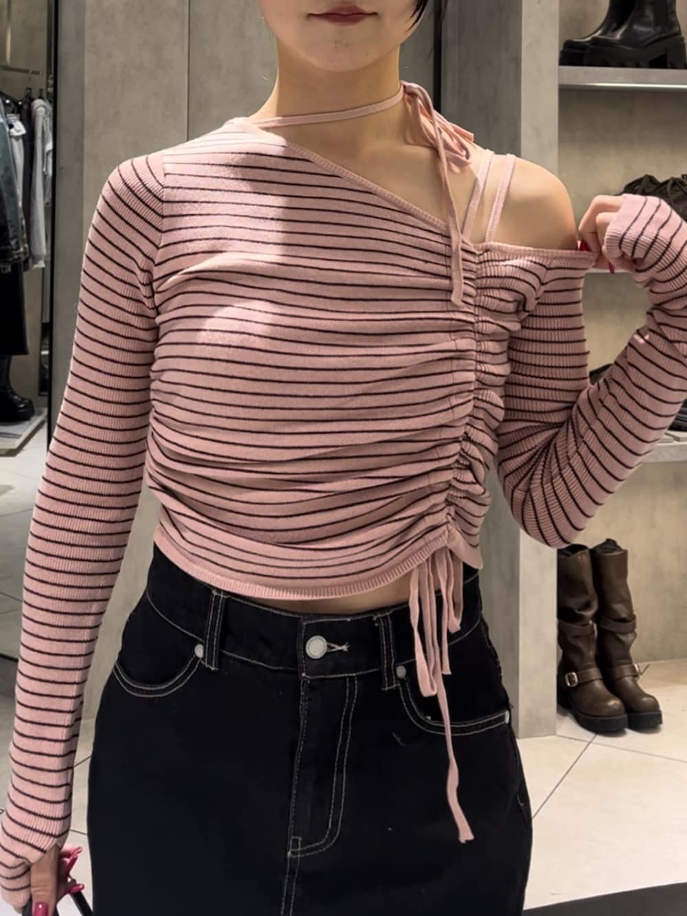 ピンク系のニット/セーター、ブルー系のスカート、ブラウン系のハンドバッグを着用したレディースの冬コーディネートの6枚目の写真