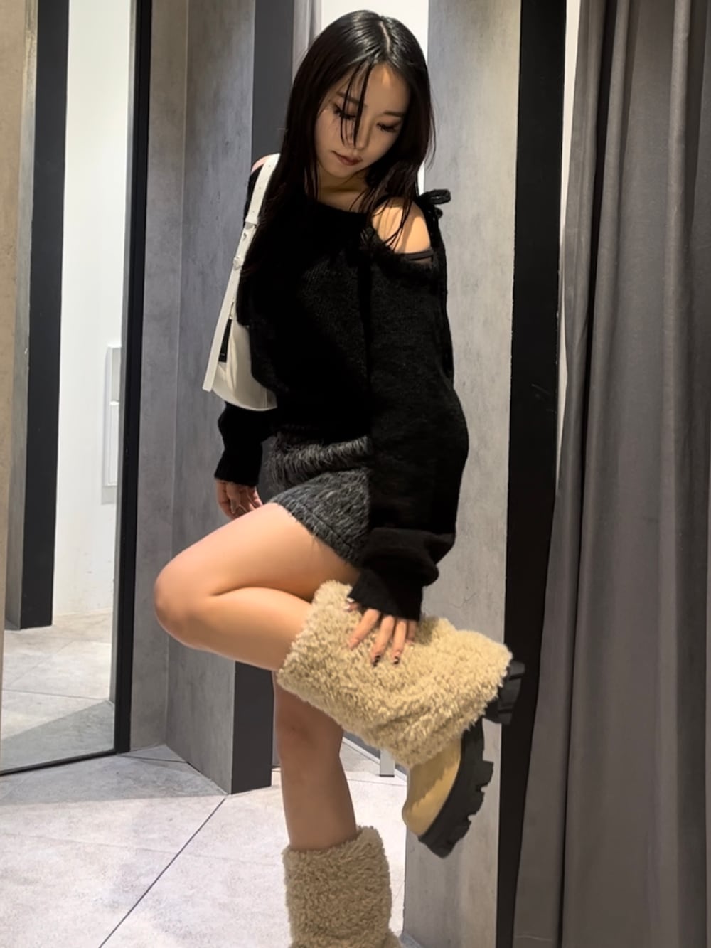 ホワイト系のブルゾン、ブラック系のニット/セーター、グレー系のその他パンツを着用したレディースの冬コーディネートの6枚目の写真