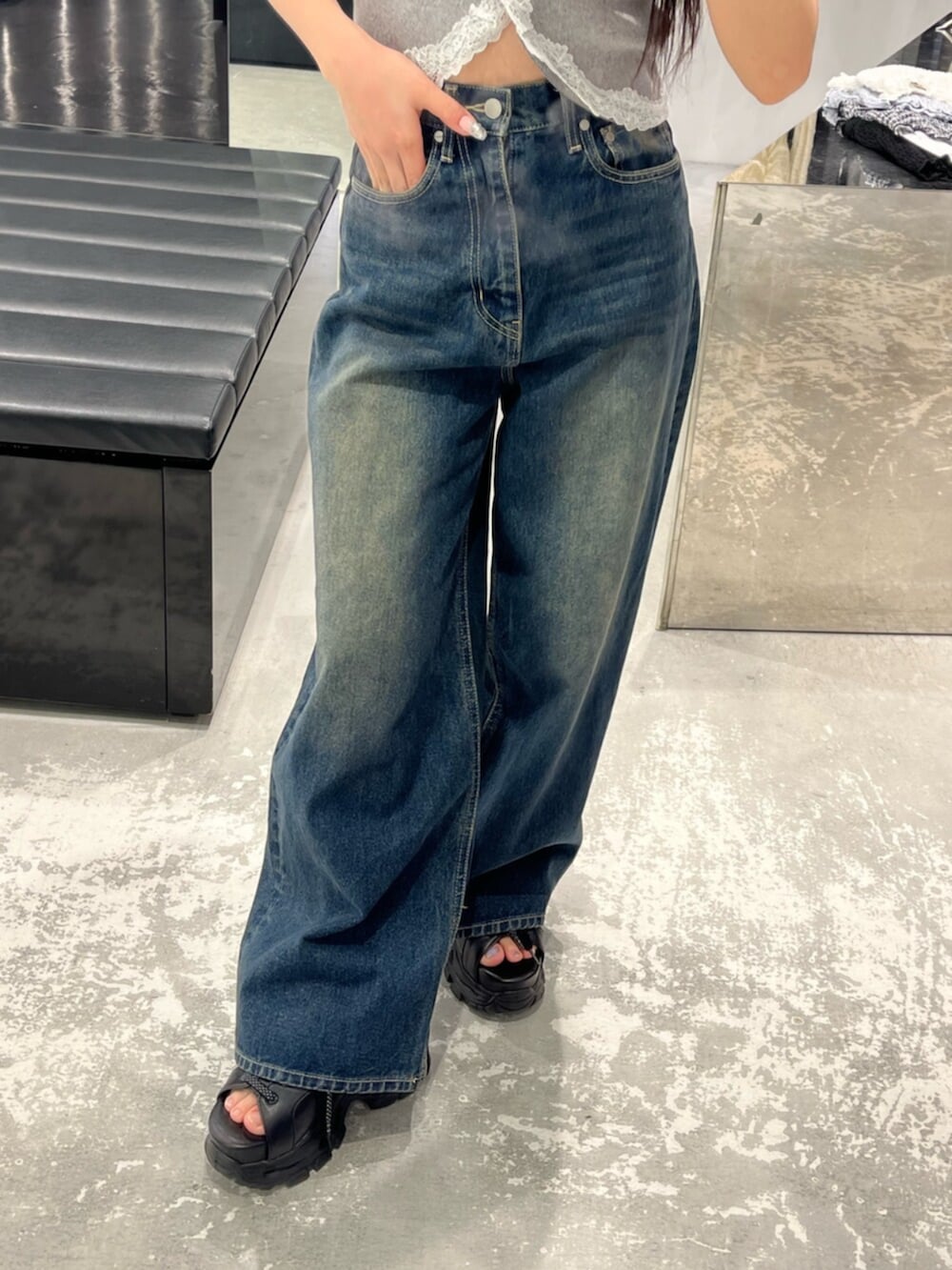 ブルー系のデニムパンツ、グレー系のニット/セーター、ブラック系のサンダルを着用したレディースの春コーディネートの6枚目の写真