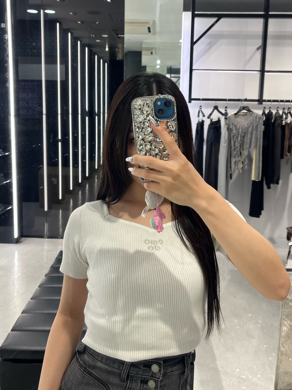ホワイト系のニット/セーター、ブラック系のデニムパンツ、ブラック系のサンダルを着用したレディースの春コーディネートの4枚目の写真