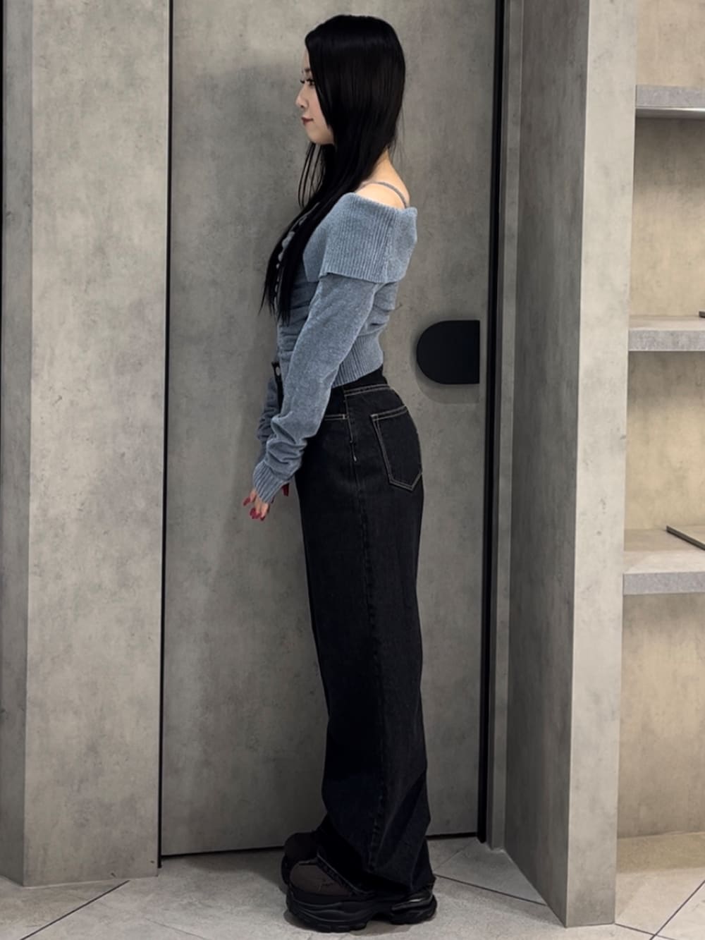 ブルー系のニット/セーター、ブルー系のデニムパンツ、グリーン系のスニーカーを着用したレディースの冬コーディネートの2枚目の写真