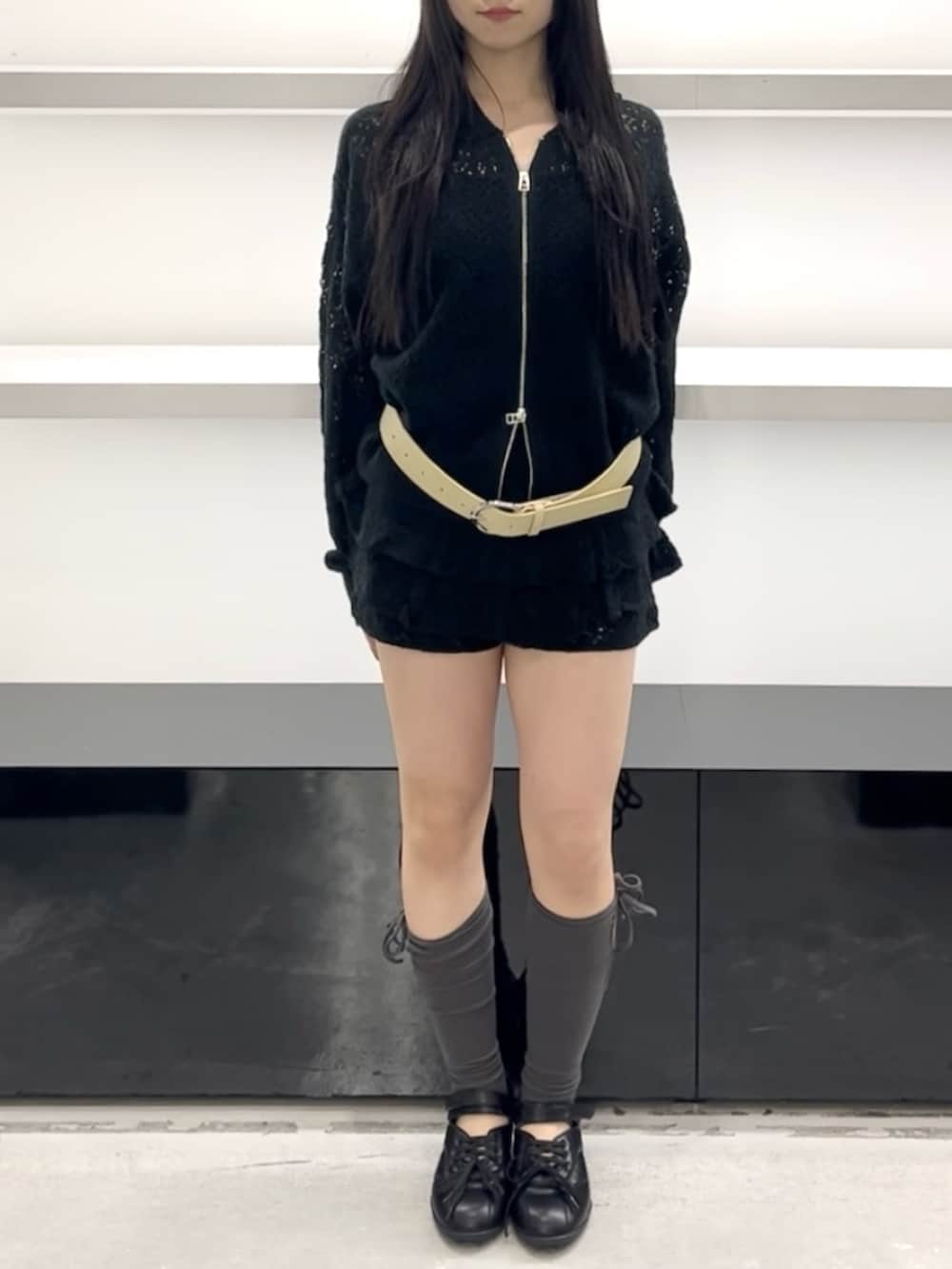 ブラック系のパーカー、ブラック系のスカート、ブラック系のスニーカーを着用したレディースの春コーディネートの6枚目の写真