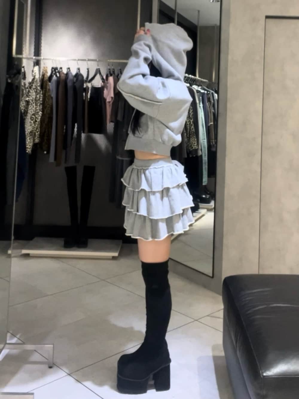 グレー系のパーカー、グレー系のスカート、ブラック系のショルダーバッグを着用したレディースの秋コーディネートの3枚目の写真