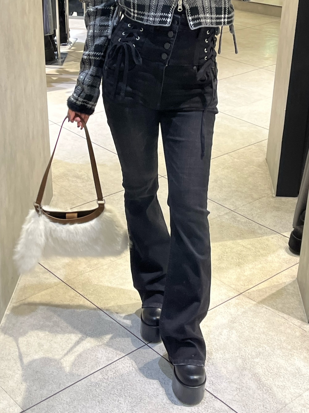 ブラック系のニット/セーター、ブラック系のデニムパンツ、ブラック系のブーツを着用したレディースの冬コーディネートの7枚目の写真