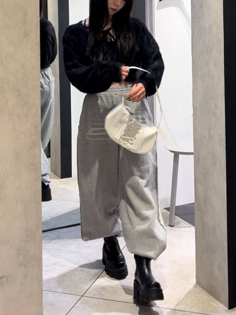 ブラック系のニット/セーター、グレー系のスウェットパンツ、ホワイト系のショルダーバッグを着用したレディースの冬コーディネートの9枚目の写真