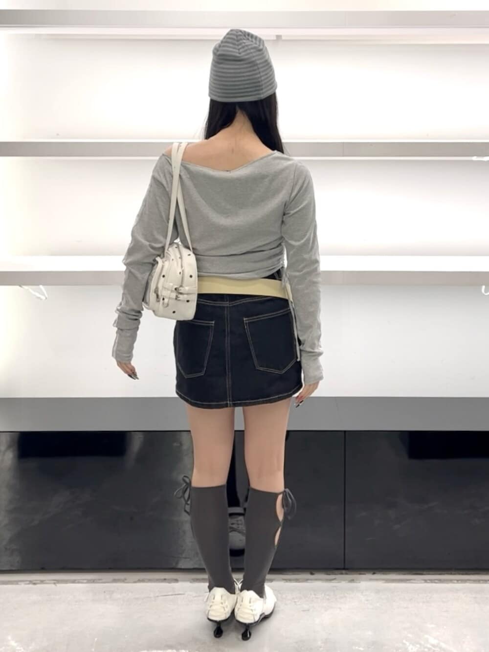 ブルー系のスカート、グレー系のTシャツ/カットソー、ホワイト系のショルダーバッグを着用したレディースの春コーディネートの4枚目の写真