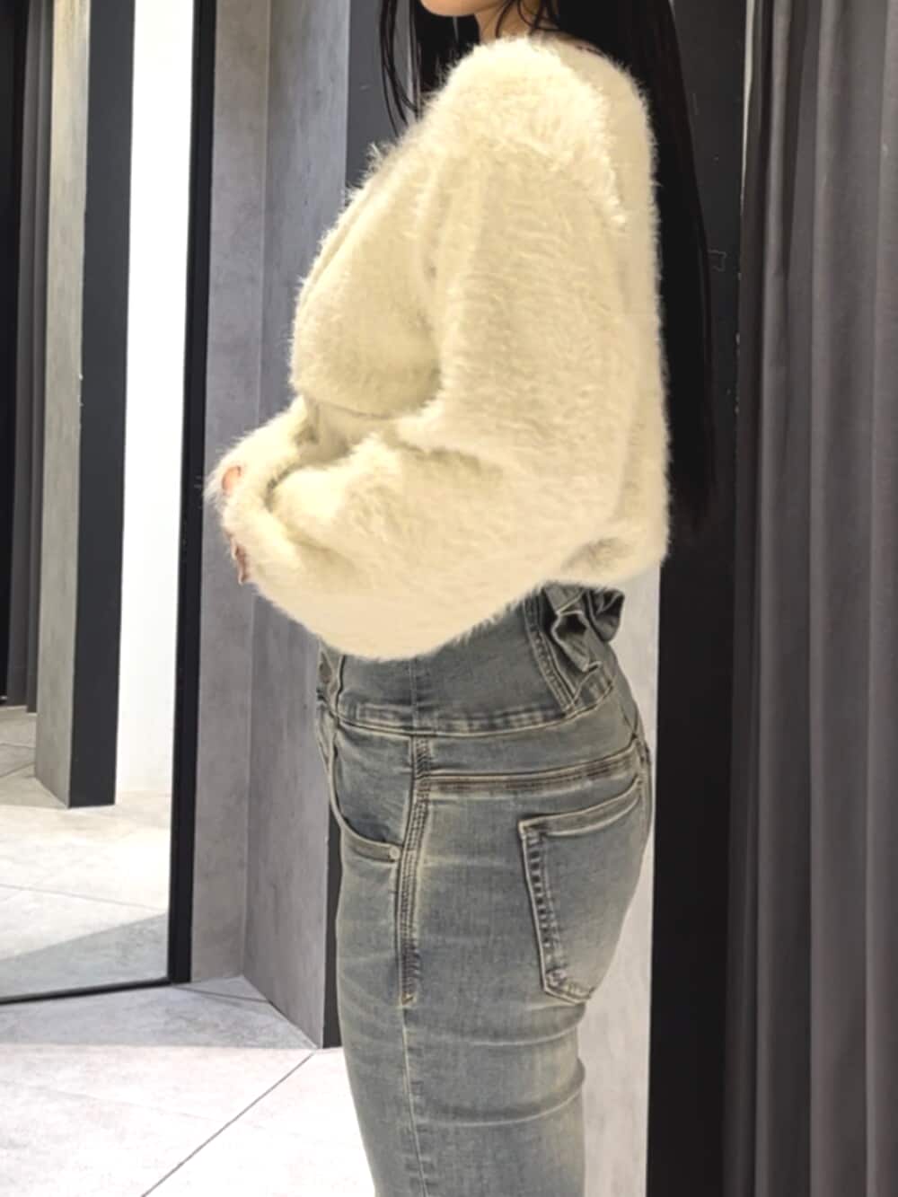 ブルー系のデニムパンツ、ホワイト系のニット/セーター、ブラック系のブーツを着用したレディースの冬コーディネートの7枚目の写真