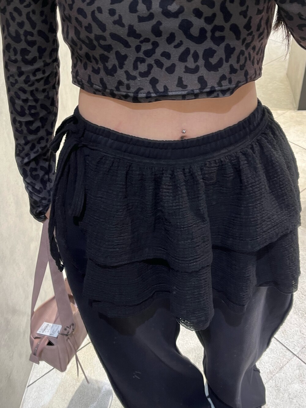 ブラック系のスカート、ブラック系のスウェットパンツ、ピンク系のハンドバッグを着用したレディースの秋コーディネートの7枚目の写真