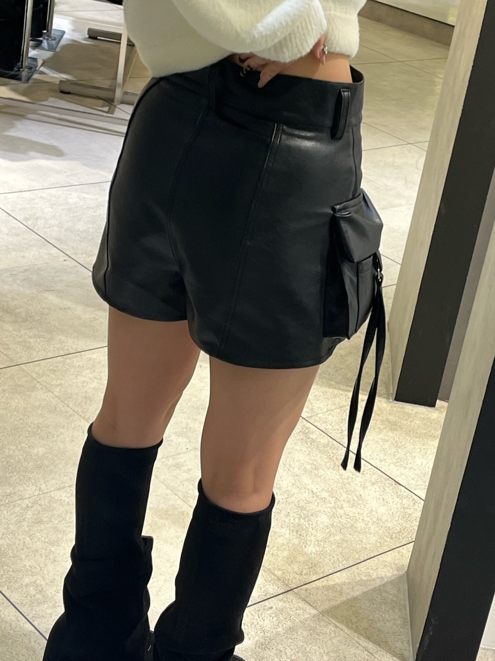 ホワイト系のニット/セーター、ブラック系のその他パンツ、ブラック系のブーツを着用したレディースの冬コーディネートの9枚目の写真