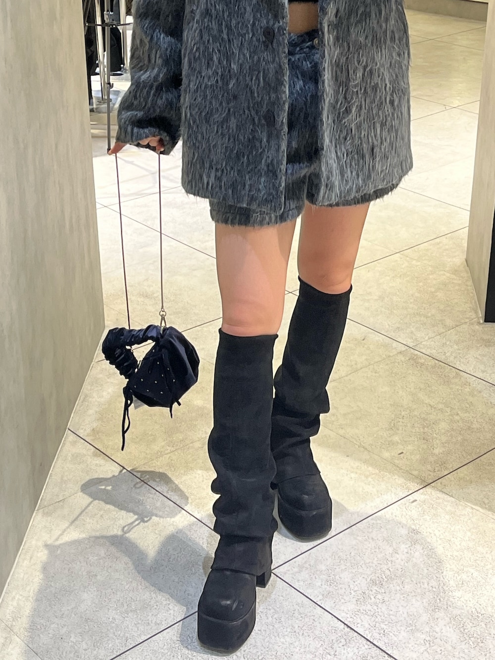 グレー系のその他アウター、ブラック系のニット/セーター、グレー系のその他パンツを着用したレディースの冬コーディネートの10枚目の写真