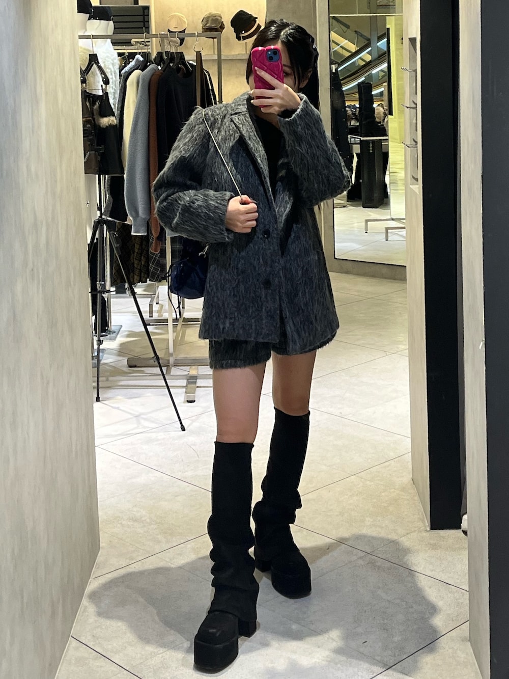 グレー系のその他アウター、ブラック系のニット/セーター、グレー系のその他パンツを着用したレディースの冬コーディネートの2枚目の写真