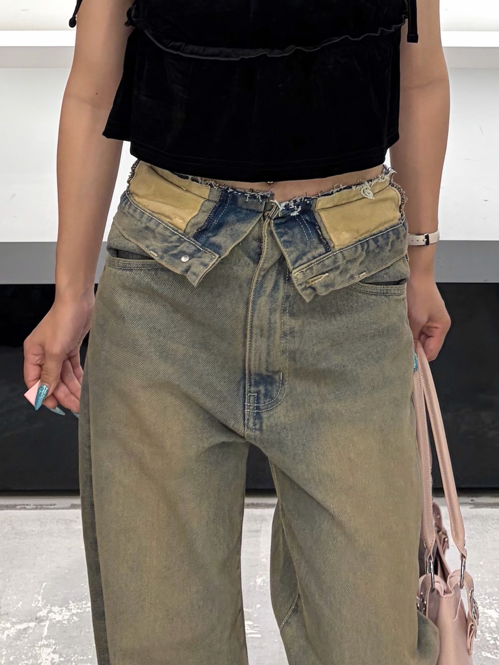 ブラック系のタンクトップ、ブラウン系のデニムパンツ、ブラウン系のブーツを着用したレディースの夏コーディネートの7枚目の写真
