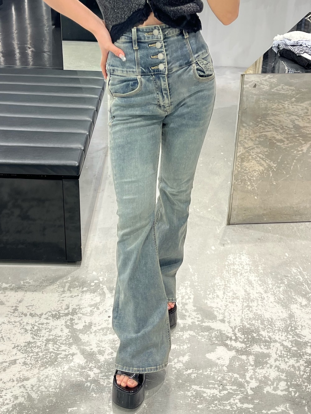 ブラック系のニット/セーター、ブルー系のデニムパンツ、ブラック系のサンダルを着用したレディースの春コーディネートの7枚目の写真