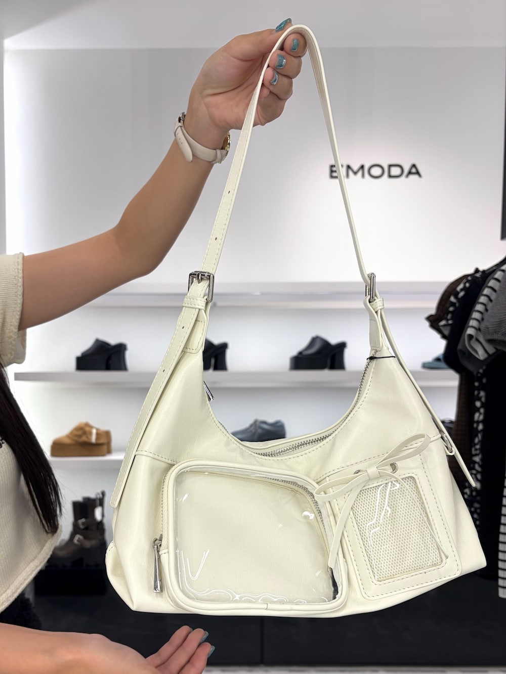 ホワイト系のニット/セーター、ホワイト系のハンドバッグ、ブラック系のその他パンツを着用したレディースの夏コーディネートの9枚目の写真