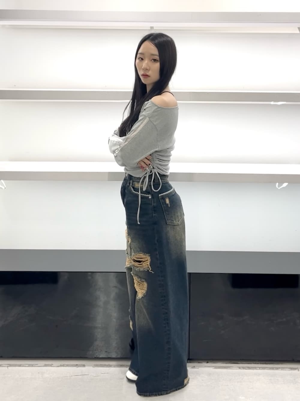 グレー系のTシャツ/カットソー、ブルー系のデニムパンツ、ホワイト系のスニーカーを着用したレディースの春コーディネートの3枚目の写真