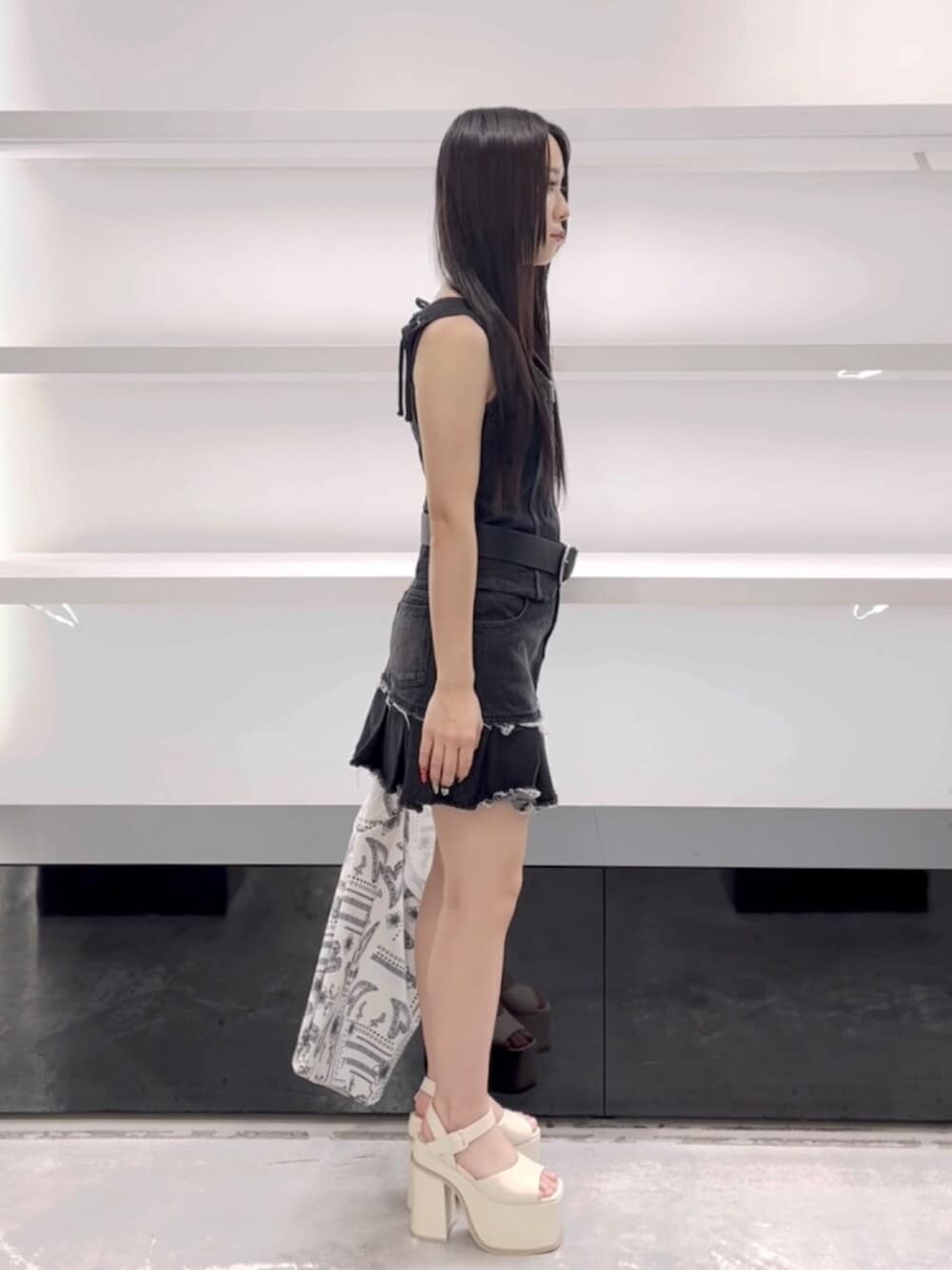 ホワイト系のサンダル、ホワイト系のトートバッグ、ブラック系のワンピースを着用したレディースの春コーディネートの3枚目の写真