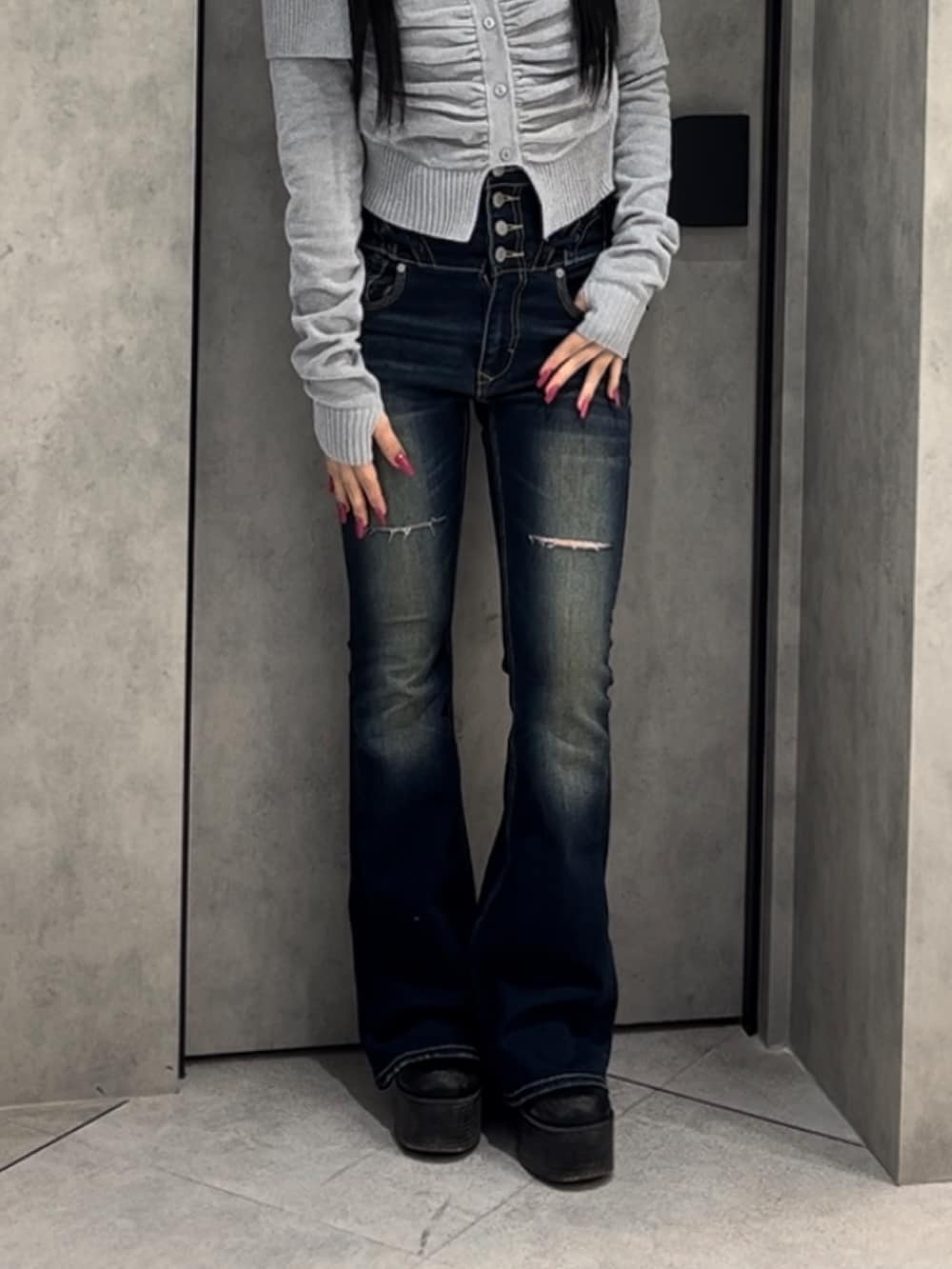 グレー系のニット/セーター、ブルー系のデニムパンツ、ブラック系のブーツを着用したレディースの冬コーディネートの9枚目の写真