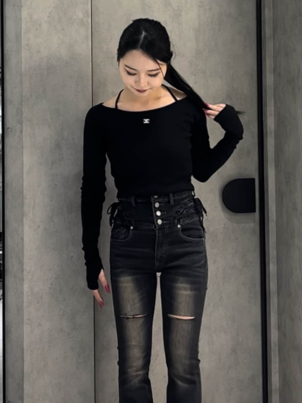 ブラック系のTシャツ/カットソー、ブラック系のデニムパンツ、ブラック系のブーツを着用したレディースの冬コーディネートの8枚目の写真