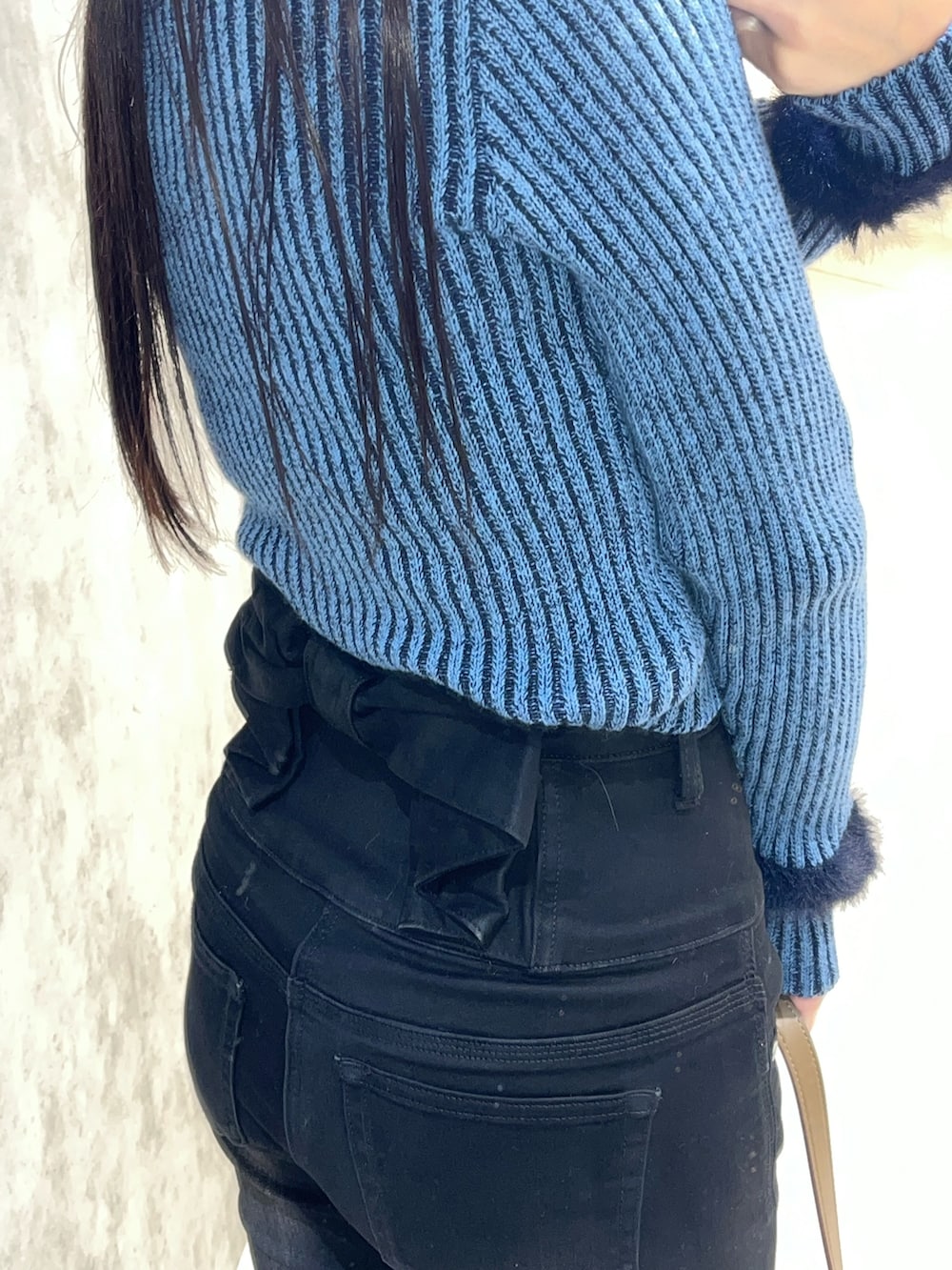 ブルー系のニット/セーター、ブラック系のデニムパンツ、ベージュ系のショルダーバッグを着用したレディースの冬コーディネートの8枚目の写真