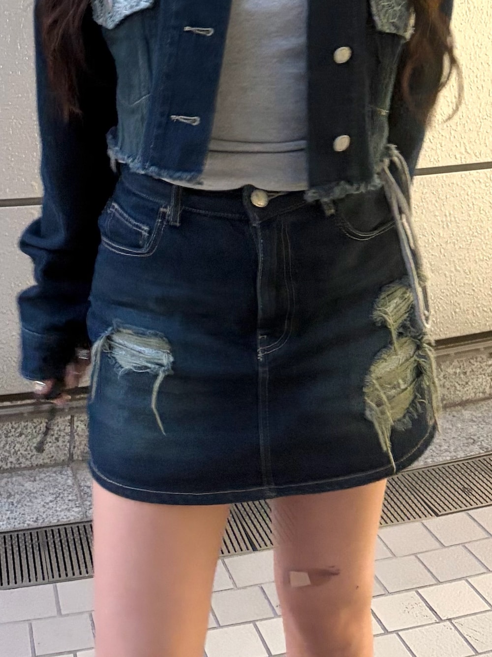 ブルー系のスカート、ブラック系のブーツ、グレー系のTシャツ/カットソーを着用したレディースの秋コーディネートの10枚目の写真