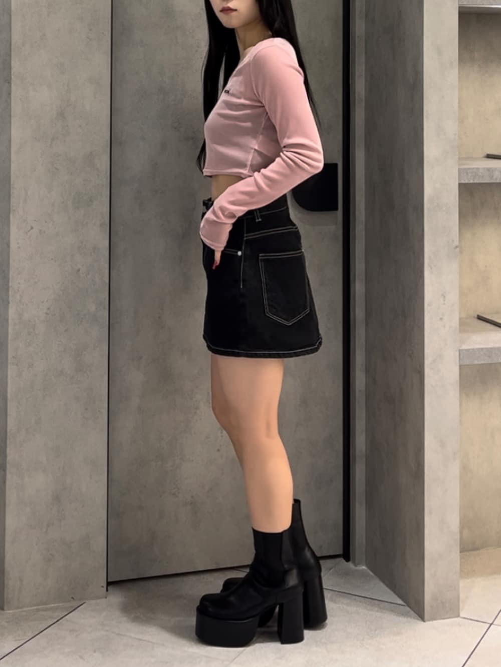 ブラック系のブルゾン、ピンク系のTシャツ/カットソー、ブルー系のスカートを着用したレディースの冬コーディネートの10枚目の写真