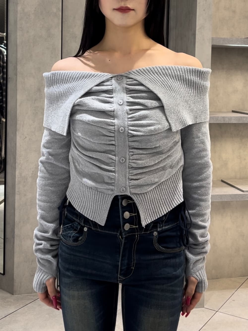 グレー系のニット/セーター、ブルー系のデニムパンツ、ブラック系のブーツを着用したレディースの冬コーディネートの5枚目の写真