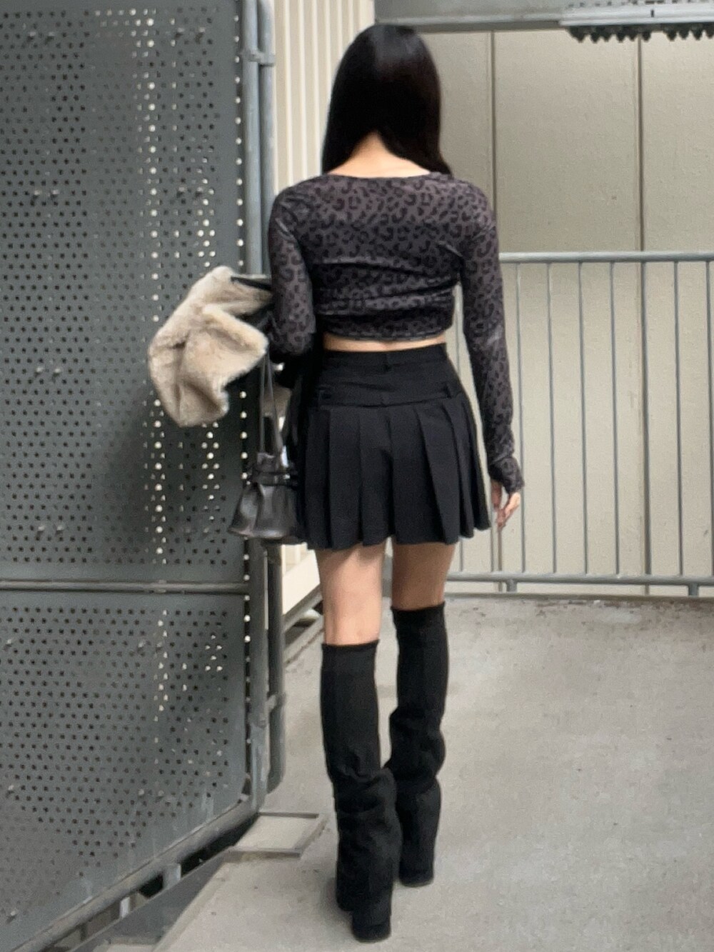 ブラック系のショルダーバッグ、ブラック系のブーツ、ブラック系のスカートを着用したレディースの秋コーディネートの9枚目の写真