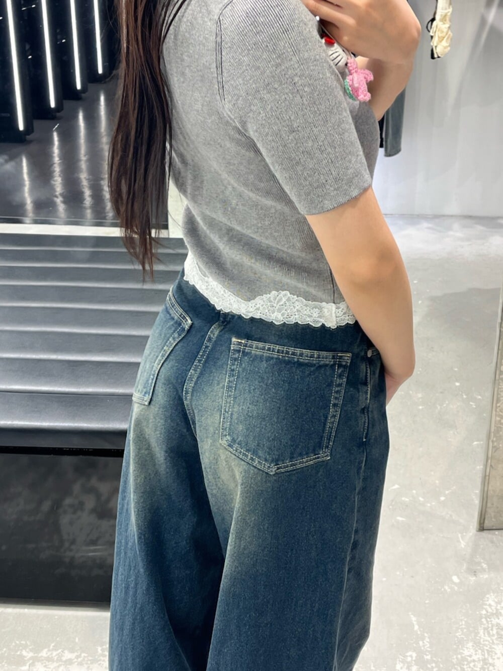 ブルー系のデニムパンツ、グレー系のニット/セーター、ブラック系のサンダルを着用したレディースの春コーディネートの9枚目の写真