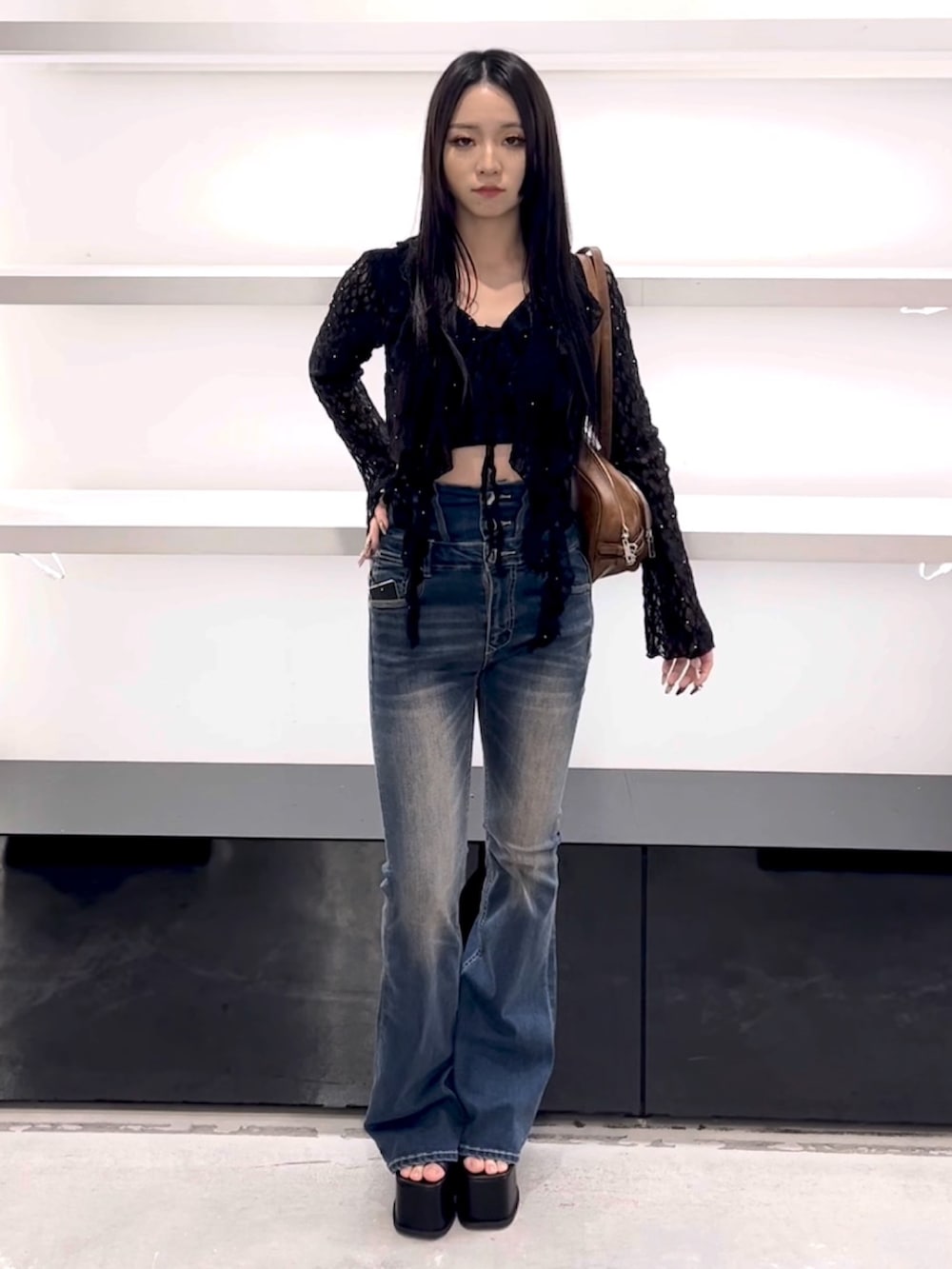 ブラック系のTシャツ/カットソー、ブルー系のデニムパンツ、ブラウン系のショルダーバッグを着用したレディースの春コーディネートの2枚目の写真