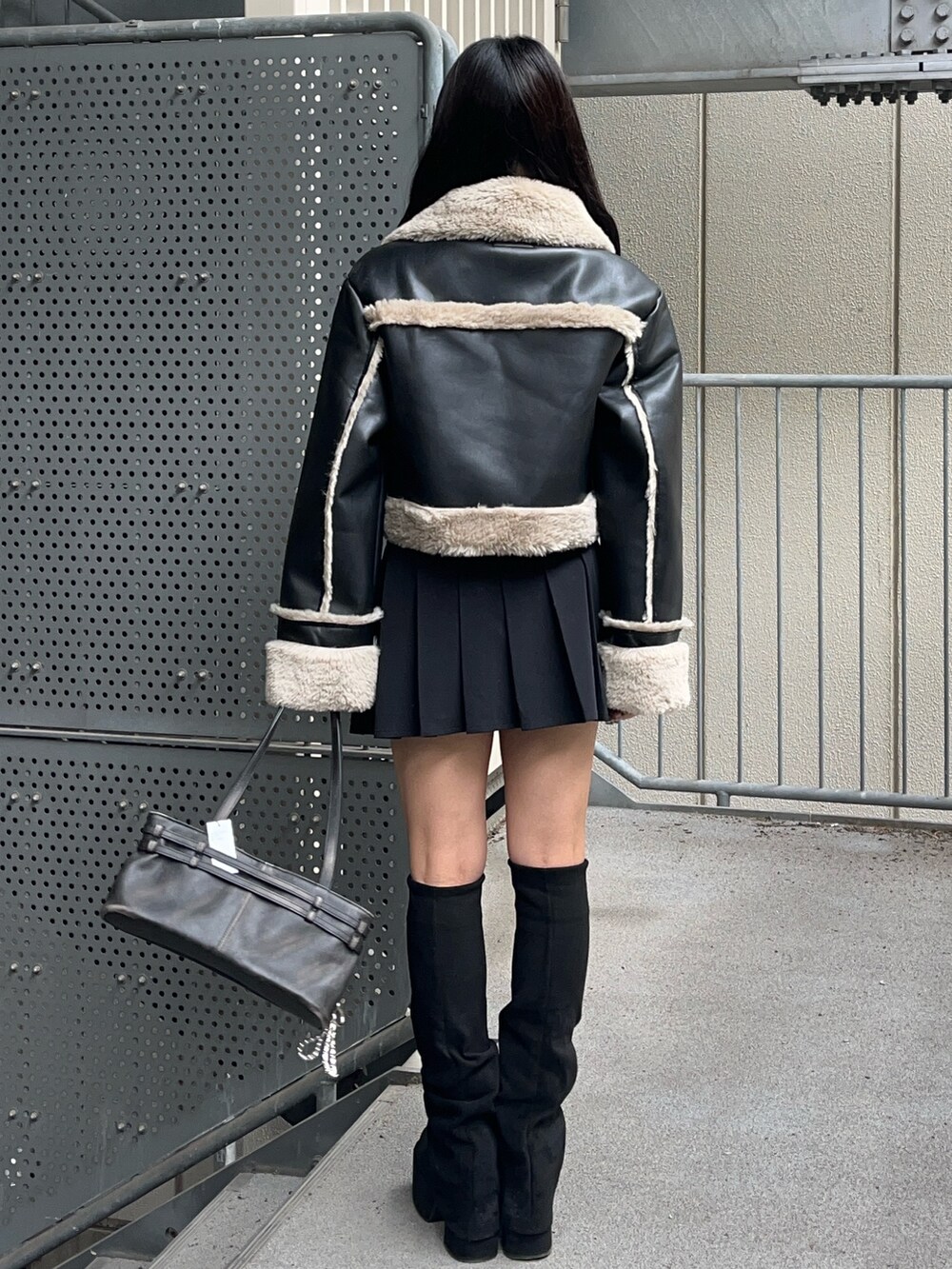 ブラック系のショルダーバッグ、ブラック系のブーツ、ブラック系のスカートを着用したレディースの秋コーディネートの3枚目の写真