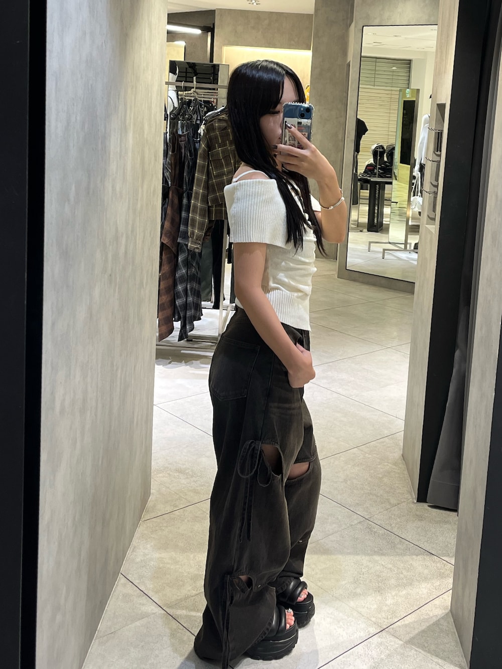 ホワイト系のニット/セーター、ブラック系のデニムパンツ、ブラック系のサンダルを着用したレディースの秋コーディネートの3枚目の写真