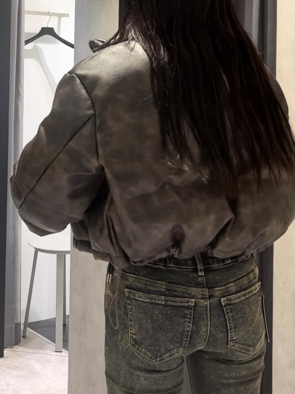 ブラウン系のダウンジャケット/コート、ホワイト系のニット/セーター、ブルー系のデニムパンツを着用したレディースの冬コーディネートの9枚目の写真