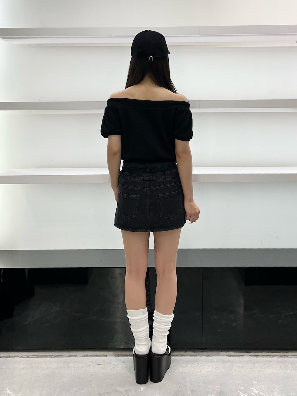 ブラック系のスウェット、ブラック系のスカート、ブラック系のサンダルを着用したレディースの夏コーディネートの3枚目の写真