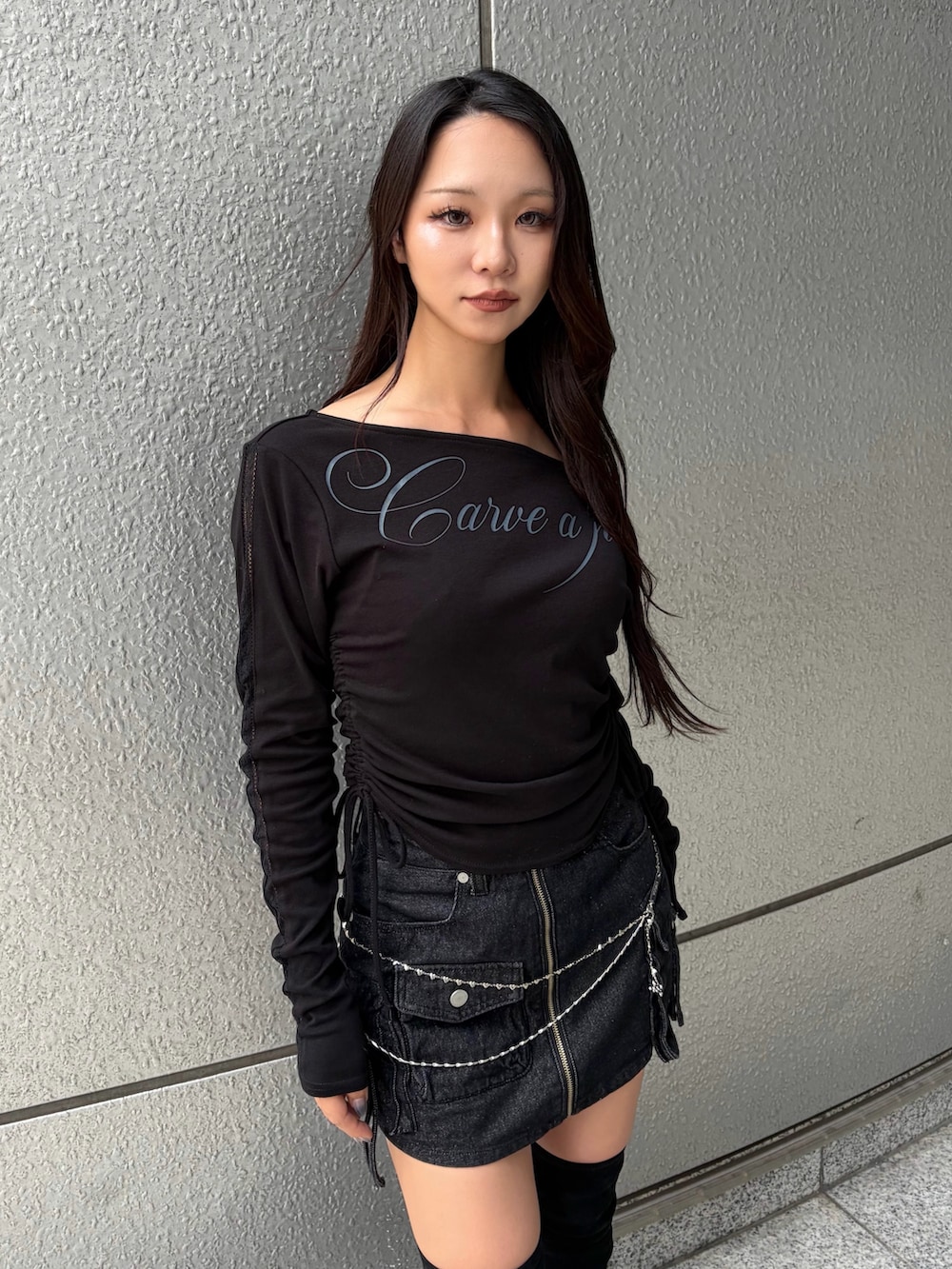 ブラック系のTシャツ/カットソー、ブラック系のスカート、ブラック系のブーツを着用したレディースの秋コーディネートの6枚目の写真
