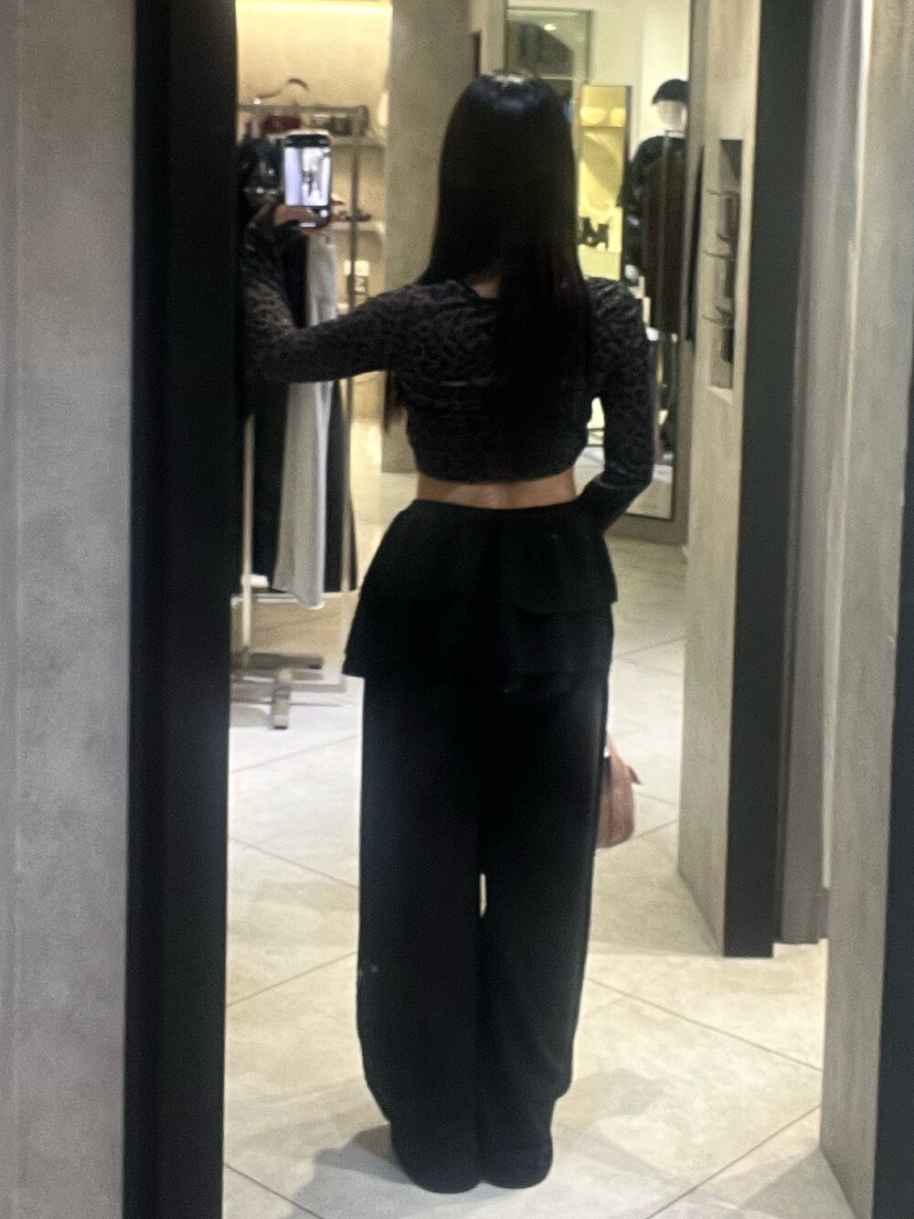 ブラック系のスカート、ブラック系のスウェットパンツ、ピンク系のハンドバッグを着用したレディースの秋コーディネートの3枚目の写真