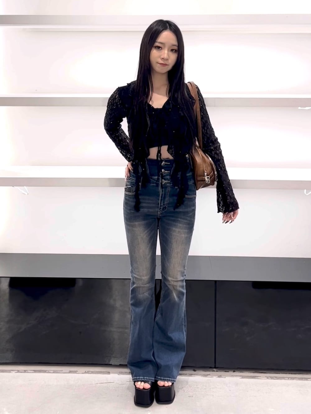 ブラック系のTシャツ/カットソー、ブルー系のデニムパンツ、ブラウン系のショルダーバッグを着用したレディースの春コーディネートの5枚目の写真