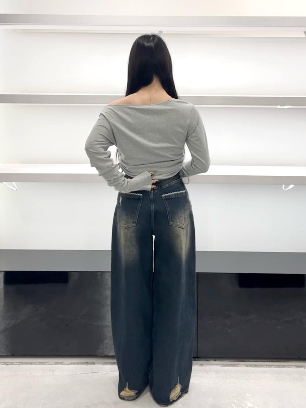 グレー系のTシャツ/カットソー、ブルー系のデニムパンツ、ホワイト系のスニーカーを着用したレディースの春コーディネートの4枚目の写真