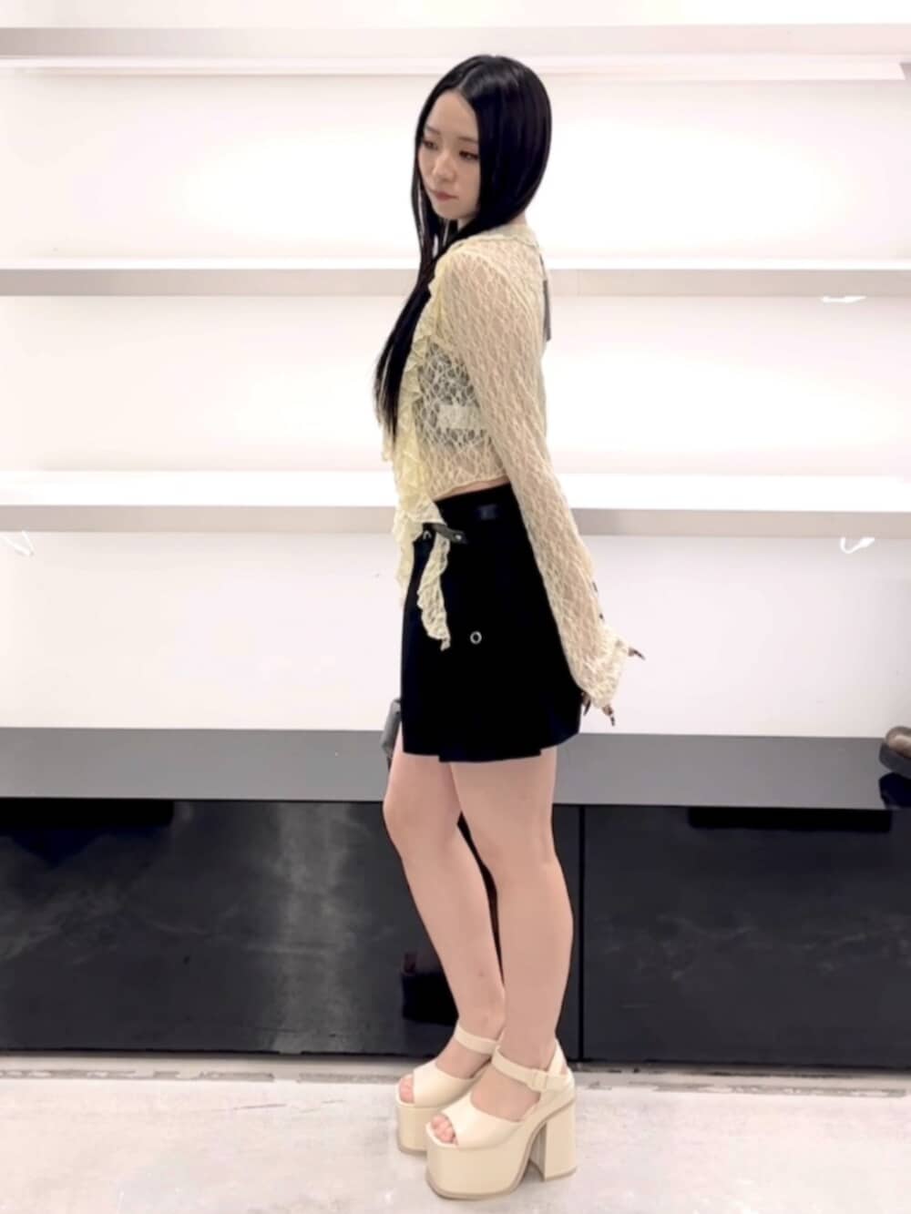 ブラック系のハンドバッグ、ブラック系のスカート、イエロー系のTシャツ/カットソーを着用したレディースの春コーディネートの3枚目の写真